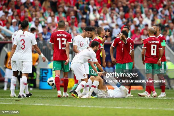 Cristiano Ronaldo of Portugal is helped to his feet by teammate Joao Moutinho during the 2018 FIFA World Cup Russia group B match between Portugal...