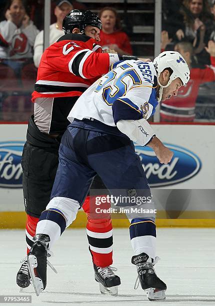 Cam Janssen of the St. Louis Blues trades punches with Pierre-Luc Letourneau-Leblond of the New Jersey Devils during their first period fight at the...