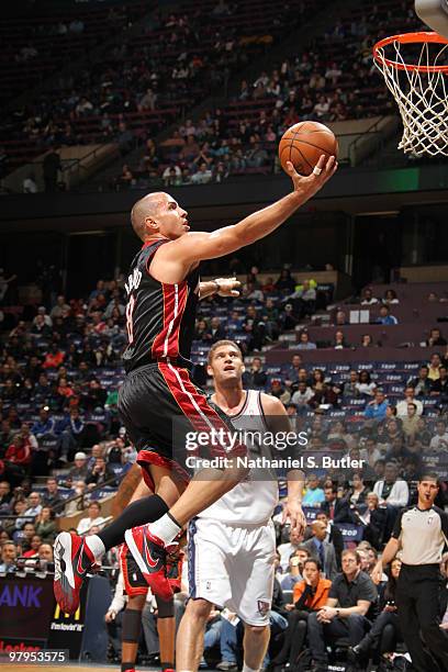 Carlos Arroyo of the Miami Heat shoots against Brook Lopez of the New Jersey Nets on March 22, 2010 at the IZOD Center in East Rutherford, New...