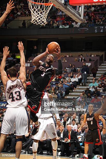 Dwyane Wade of the Miami Heat shoots against Kris Humphries of the New Jersey Nets on March 22, 2010 at the IZOD Center in East Rutherford, New...