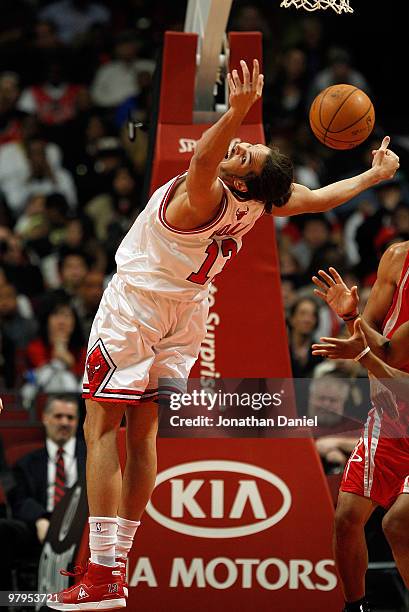 Joakim Noah of the Chicago Bulls falls backwards while trying to rebound the ball against the Houston Rockets at the United Center on March 22, 2010...
