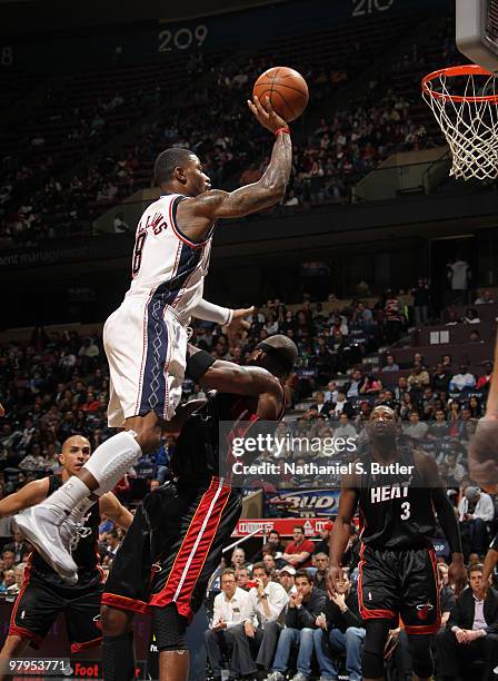 Terrence Williams of the New Jersey Nets shoots against Jermaine O'Neal of the Miami Heat on March 22, 2010 at the IZOD Center in East Rutherford,...