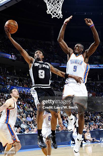 Roger Mason Jr. #8 of the San Antonio Spurs goes to the basket against Serge Ibaka of the Oklahoma City Thunder during the game at the Ford Center on...