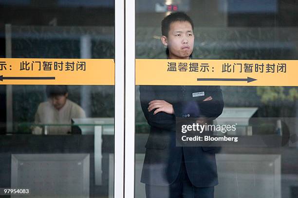 Security guard looks out from the Google Inc. Office in Beijing, China, on Tuesday, March 23, 2010. Google Inc., following through on a pledge to...