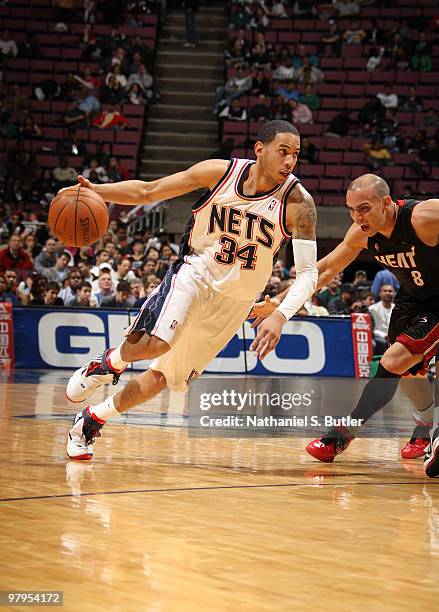 Devin Harris of the New Jersey Nets drives against Carlos Arroyo of the Miami Heat on March 22, 2010 at the IZOD Center in East Rutherford, New...