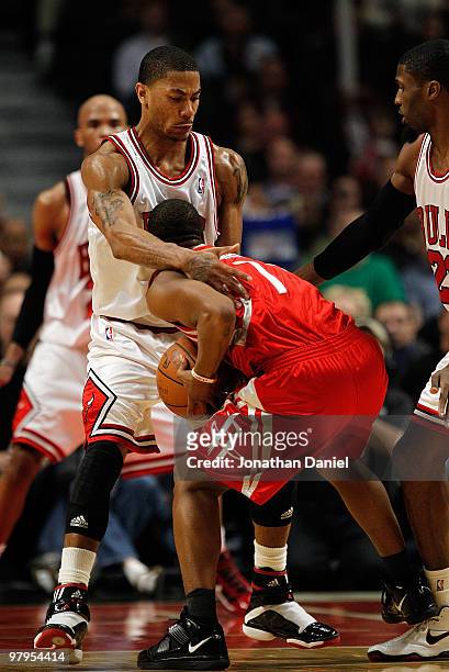 Kyle Lowry of the Houston Rockets ends up with his face in the chest of Derrick Rose of the Chicago Bulls while trying to drive to the basket at the...