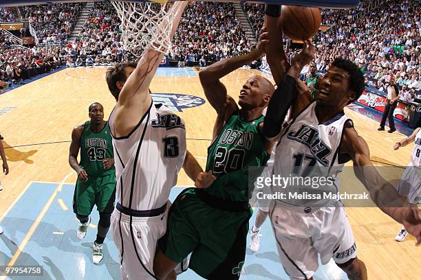 Mehmet Okur and Ronnie Price of the Utah Jazz block the shot by Ray Allen of the Boston Celtics at EnergySolutions Arena on March 22, 2010 in Salt...