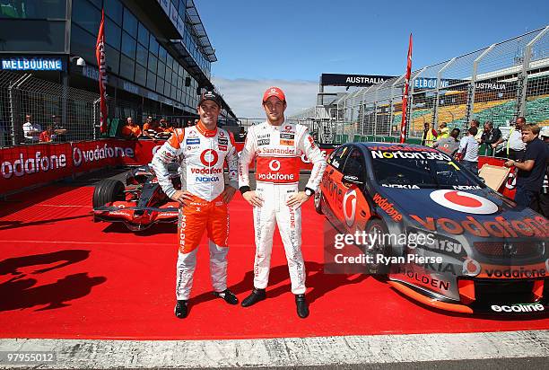 Jenson Button of Vodafone McLaren Mercedes F1 Team and Jamie Whincup of the Vodafone V8 Supercars Team pose during previews for the Australian...