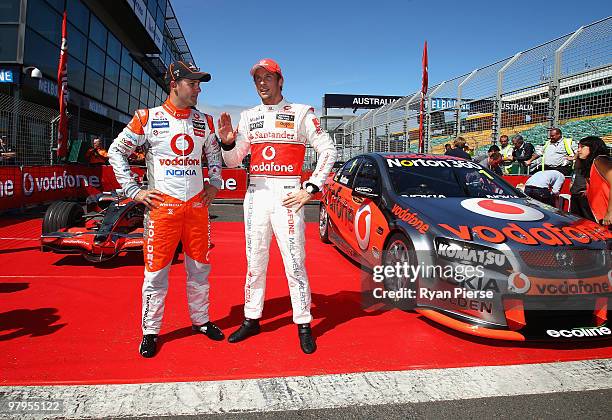 Jenson Button of Vodafone McLaren Mercedes F1 Team and Jamie Whincup of the Vodafone V8 Supercar Team pose during previews for the Australian Formula...