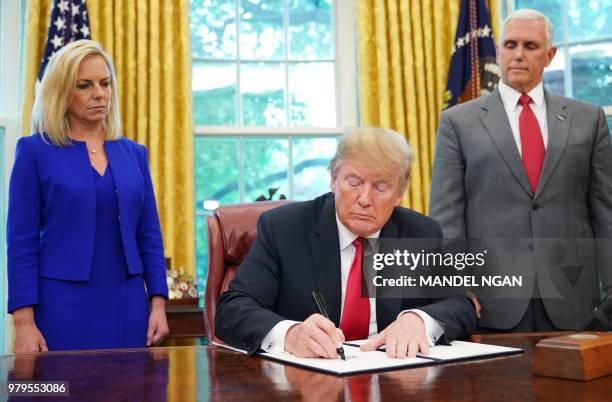 Watched by Homeland Security Secretary Kirstjen Nielsen and Vice President Mike Pence, US President Donald Trump signs an executive order on...