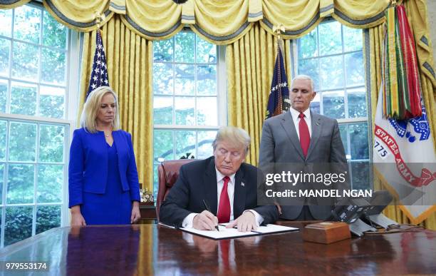 Watched by Homeland Security Secretary Kirstjen Nielsen and Vice President Mike Pence, US President Donald Trump signs an executive order on...