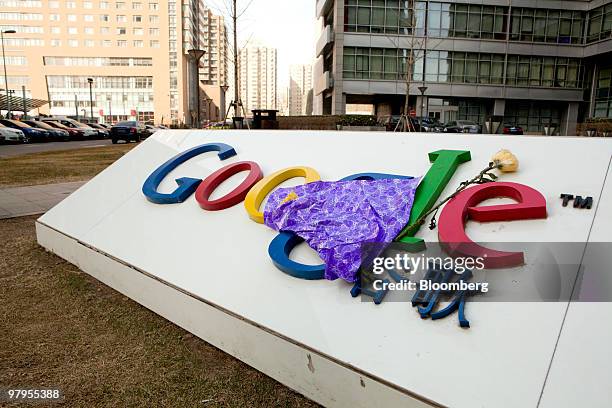 Flowers are seen on a sign outside the Google Inc. Office in Beijing, China, on Tuesday, March 23, 2010. Google Inc.'s looming withdrawal from China...