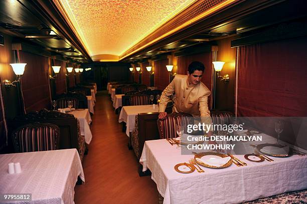 Lifestyle-India-tourism-rail-travel, FOCUS by Sailendra Sil An Indian train assistant arranges a table setting in the restaurant of the Maharajas'...