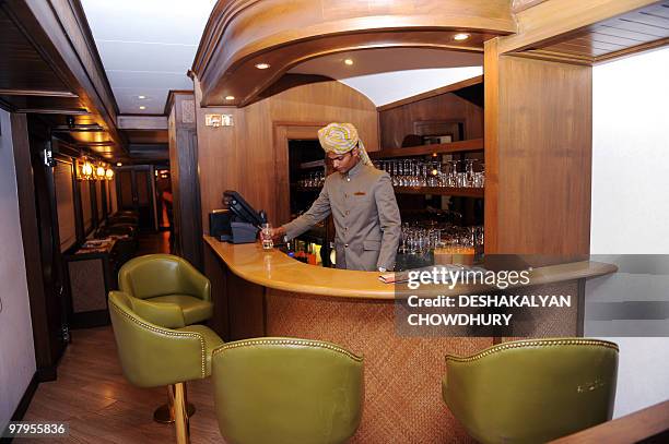 Lifestyle-India-tourism-rail-travel, FOCUS by Sailendra Sil An Indian train assistant prepares a drink at the bar on the Maharajas' Express, the...