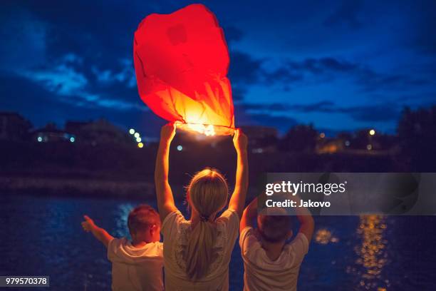 releasing paper lanterns - paper lanterns stock pictures, royalty-free photos & images