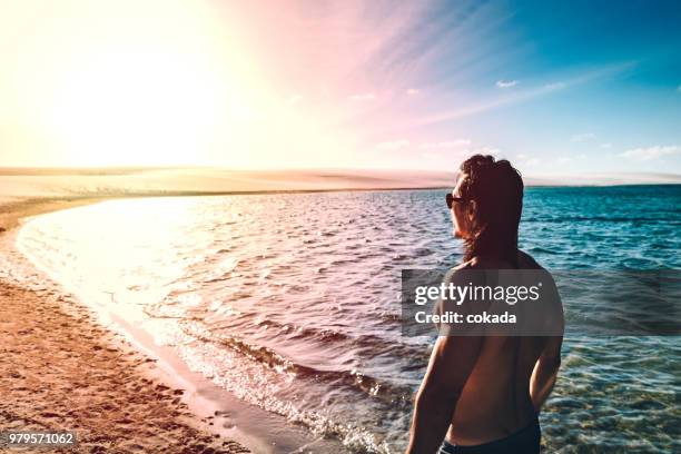 jovem, assistindo o pôr do sol no lençois maranhenses - lencois maranhenses national park - fotografias e filmes do acervo