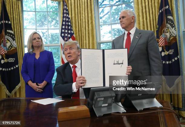 President Donald Trump, accompanied by Department of Homeland Security Secretary Kirstjen Nielsen and U.S. Vice President Mike Pence , displays an...