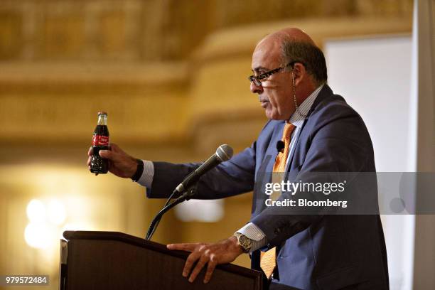 Muhtar Kent, chairman of the Coca-Cola Co., holds a bottle of Coca-Cola brand soda while speaking during an Executives Club Of Chicago luncheon in...