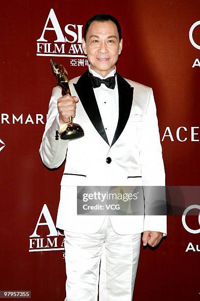 China's Wang Xueqi holds his best actor award during the 4th Asian Film Awards Ceremony at the Convention and Exhibition Centre on March 22, 2010 in...