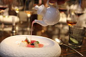 Michelin Starred Chef is serving a final touch for a dessert in a white stylish bowl.