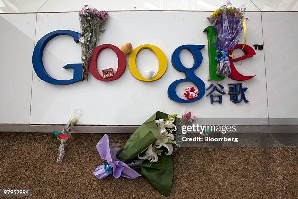 Flowers are placed on a sign outside the Google Inc. Office in Beijing, China, on Tuesday, March 23, 2010. Google Inc., following through on a pledge...