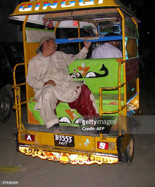 An auto-rickshaw driver transports an injured activist of Pakistan's hardline religious party Jamiat-e-Ulema Islam after a hand grenade attack at a...