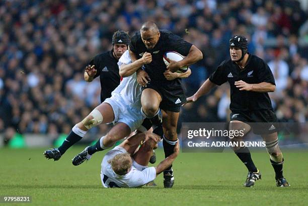 New Zealand's Jonah Lomu runs over England's Neil Back on the way to the try line during the match at Twickenham, west London 09 November 2002....