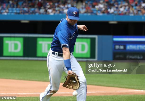 Justin Smoak of the Toronto Blue Jays can't make the play on a foul pop up in the seventh inning during MLB game action against the Atlanta Braves at...