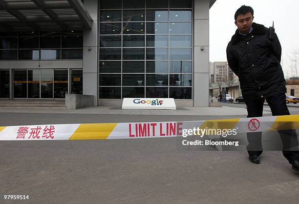 Security guard stands outside the Google Inc. Offices in Beijing, China, on Tuesday, March 23, 2010. Google Inc., following through on a pledge to...