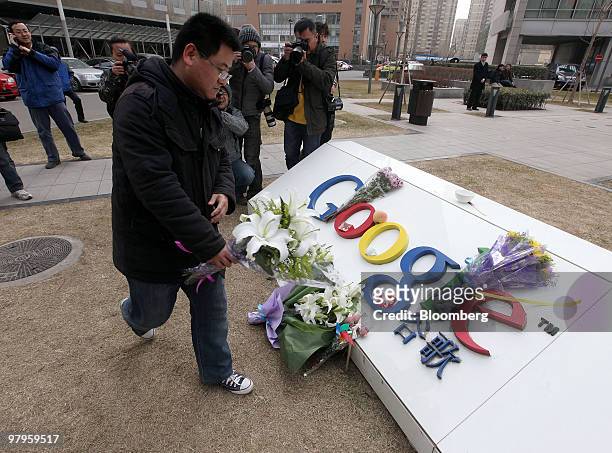 Nie Xing makes an offering of flowers outside the Google Inc. Offices in Beijing, China, on Tuesday, March 23, 2010. Google Inc., following through...