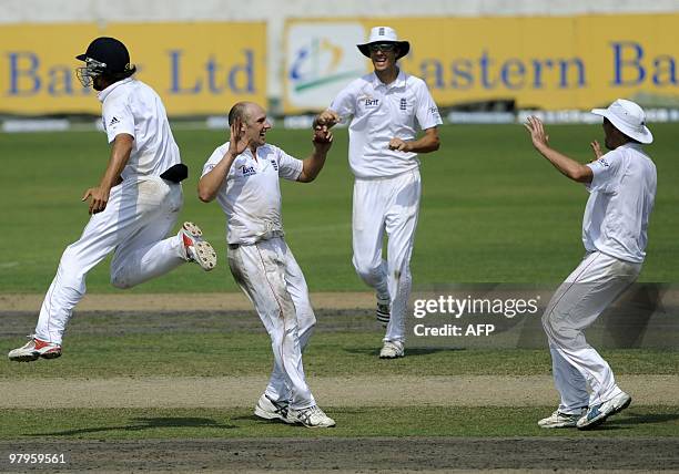 England cricket team captain Alastair Cook celebrates with teammates James Tredwell , Steven Finn and Graeme Swann after the dismissal of unseen...