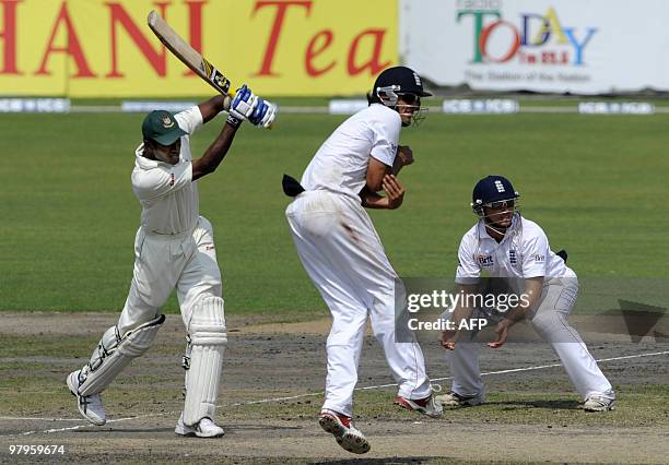 Bangladeshi cricketer Jahurul Islam plays a shot as England cricket team captain Alastair Cook jumps to avoid being struck by the ball as teammate...