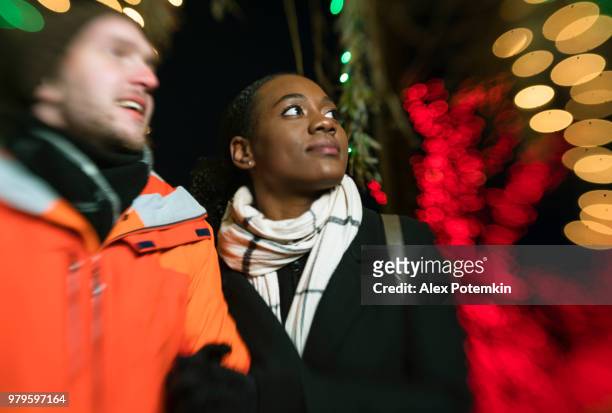 sex tussen verschillendre rassen verliefde paar, de mooie zwarte jonge vrouw en knappe jonge man, kijken kerstverlichting en plezier in de koude winterdag in brooklyn, new york. - black christmas stockfoto's en -beelden