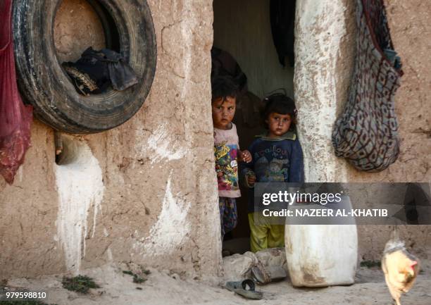Syrian children from the northern city of Manbij, displaced by fighting between the Syrian Democratic Forces and Islamic State group fighters, stand...