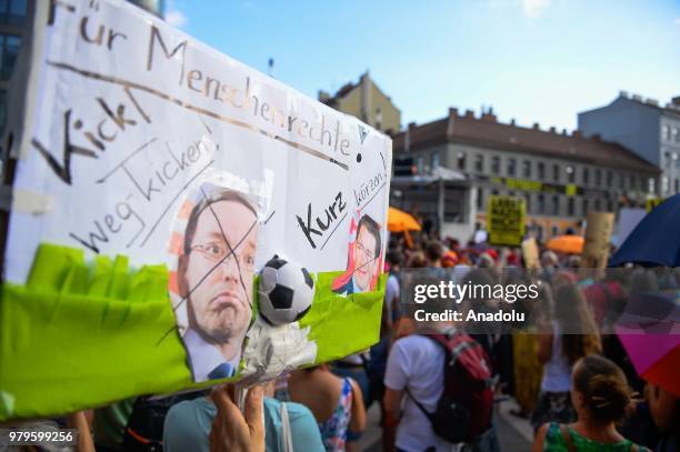 Hundreds of people hold umbrellas as a symbol of protection for refugees during a march against the conservative right wing government Vienna,...