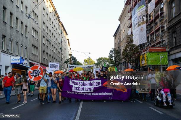 Hundreds of people hold umbrellas as a symbol of protection for refugees during a march against the conservative right wing government Vienna,...