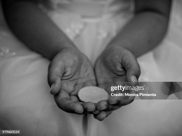 hands of girl (8-9) holding wafer - communion fotografías e imágenes de stock