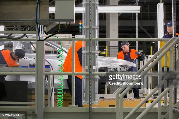 Workers inspect a vehicle body during production of a Volvo AB S60 sedan at the Volvo Cars USA plant in Ridgeville, South Carolina, U.S., on...