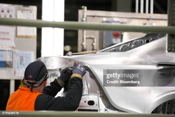 Worker inspects a vehicle body during production of a Volvo AB S60 sedan at the Volvo Cars USA plant in Ridgeville, South Carolina, U.S., on...