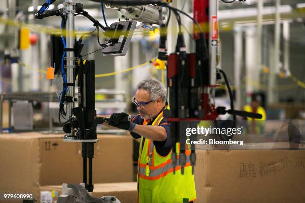 Worker assembles parts for wheels during production of a Volvo AB S60 sedan at the Volvo Cars USA plant in Ridgeville, South Carolina, U.S., on...