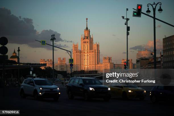 The Stalinist Kotelnicheskaya Embankment Building is illuminated by the setting sun as Moscovites make their way home on June 20, 2018 in Moscow,...