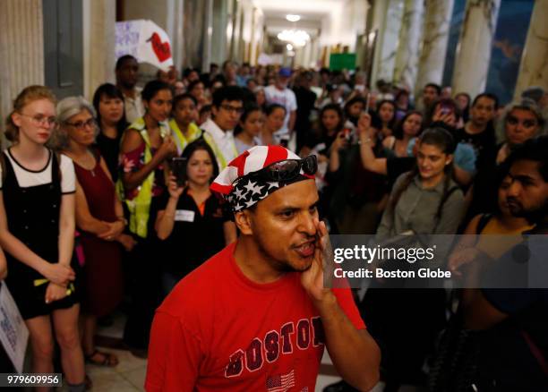 Andres Briceno, of Somerville, leads a chant in front of Massachusetts Governor Charlie Baker's office during a protest calling on lawmakers to...