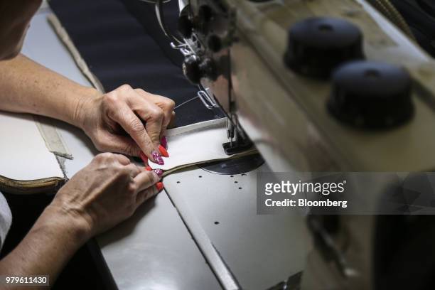 Worker sews pieces of upholstery at the Winnebago Industries Inc. Chris-Craft boat manufacturing facility in Sarasota, Florida, U.S., on Tuesday,...