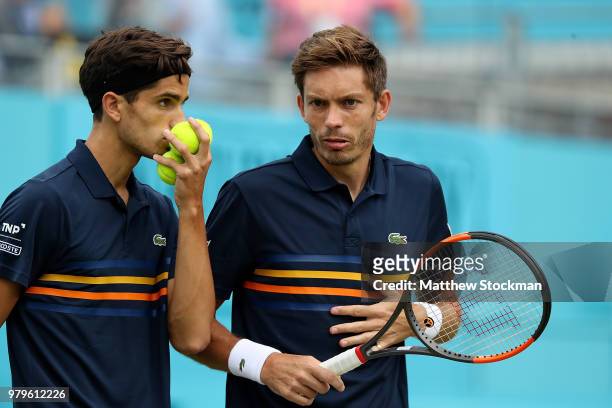 Pierre-Hughes Herbert and Nicolas Mahut of France in action during their doubles match against Nick Kyrgios and Lleyton Hewitt of Australia on Day...