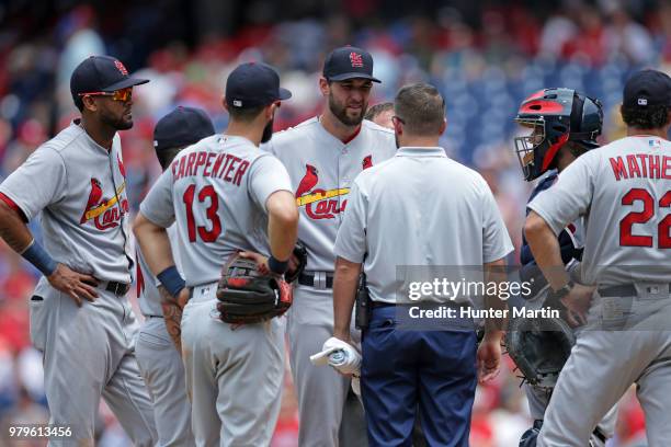 Starting pitcher Michael Wacha of the St. Louis Cardinals speaks with the Cardinals team trainer before being removed from the game due to injury in...