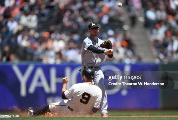 Riddle of the Miami Marlins completes the double-play throwing over the top of Brandon Belt of the San Francisco Giants in the bottom of the fourth...