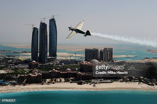 Yoshihide Muroya of Japan soars above the Emirates Palace hotel and the Etihad Towers during the Abu Dhabi Red Bull Air Race fly in and Calibration...