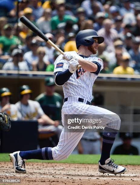 Cory Spangenberg of the San Diego Padres hits an RBI single during the third inning of a baseball game against the Oakland Athletics at PETCO Park on...