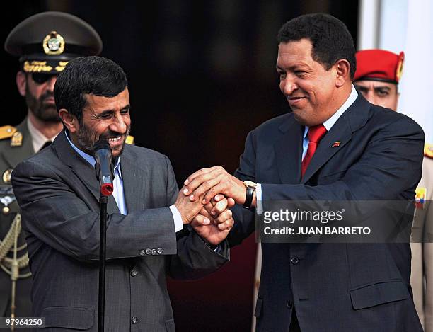 Iranian President Mahmoud Ahmadinejad greets his Venezuelan counterpart Hugo Chavez, upon his arrival at Miraflores presidential palace in Caracas on...