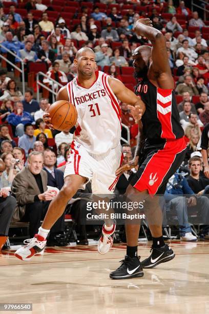 Shane Battier of the Houston Rockets moves the ball against Reggie Evans of the Toronto Raptors during the game on March 1, 2010 at the Toyota Center...